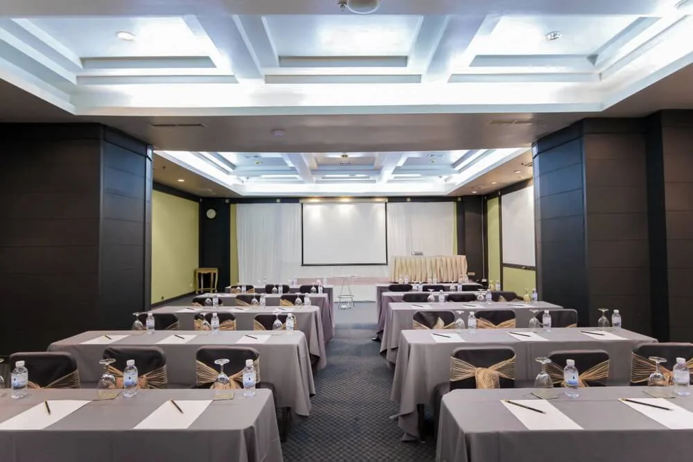 Meeting tables and presentation area in a supplied Royal Phuket City Hotel room photograph