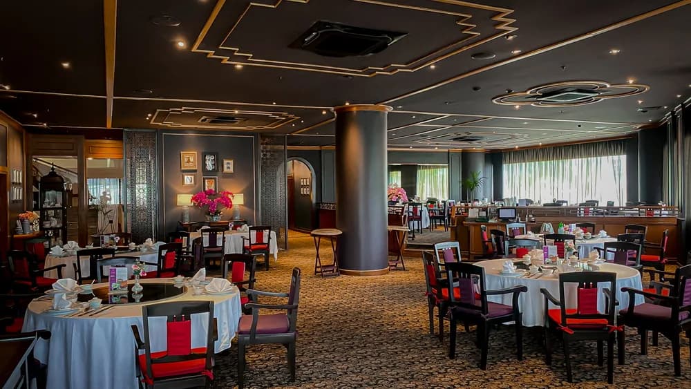 Tables set for dining in the Yan Long restaurant with decorative ceilings and window curtains