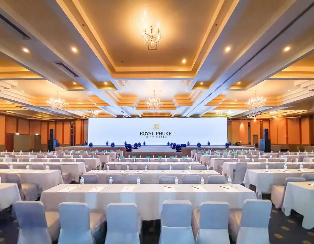 Rows of meeting tables facing a stage in a Royal Phuket City ballroom