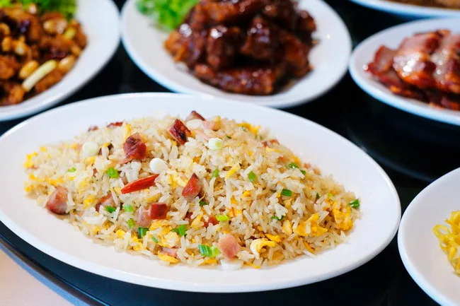 Rice on a white plate with other serving dishes behind it