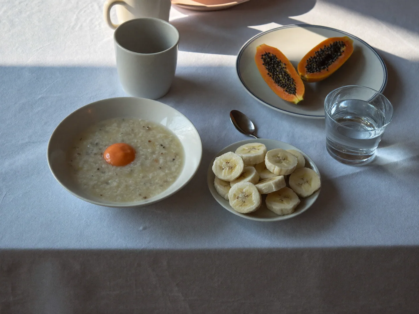 An illustrative family meal-planning table with porridge, sliced fruit and plain crockery