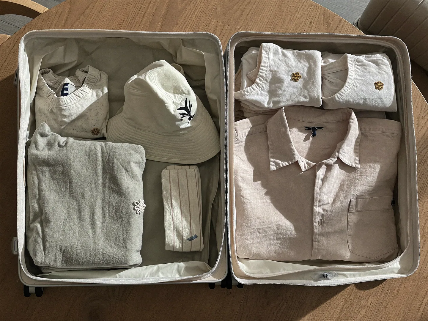 An illustrative open travel case with folded clothing in packing organisers