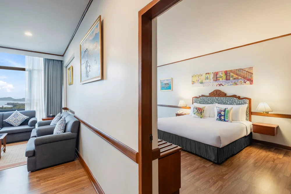 A hotel suite with a bedroom and a separate seating area