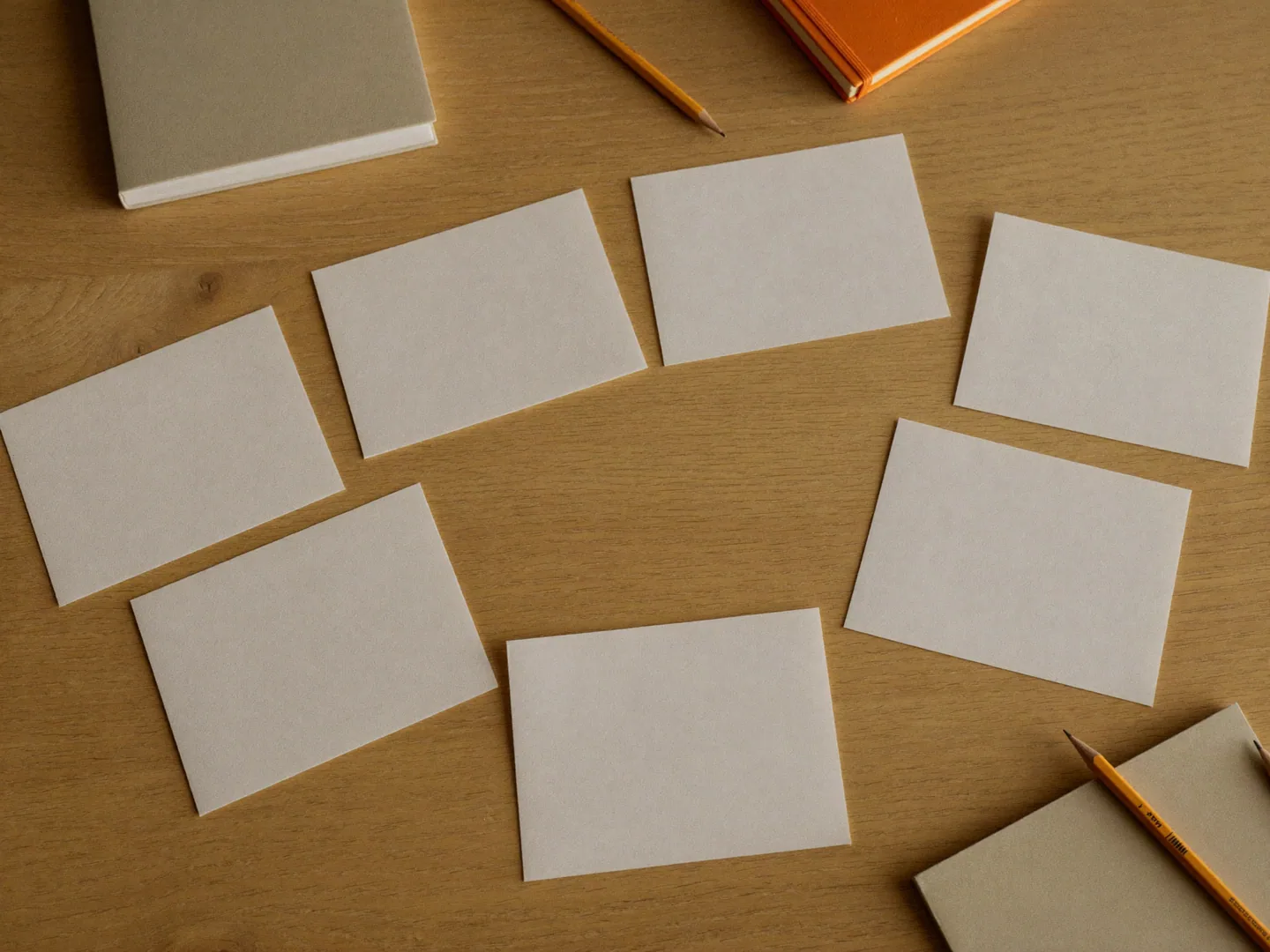 Blank cards, notebooks and pencils arranged as a meeting-planning still life