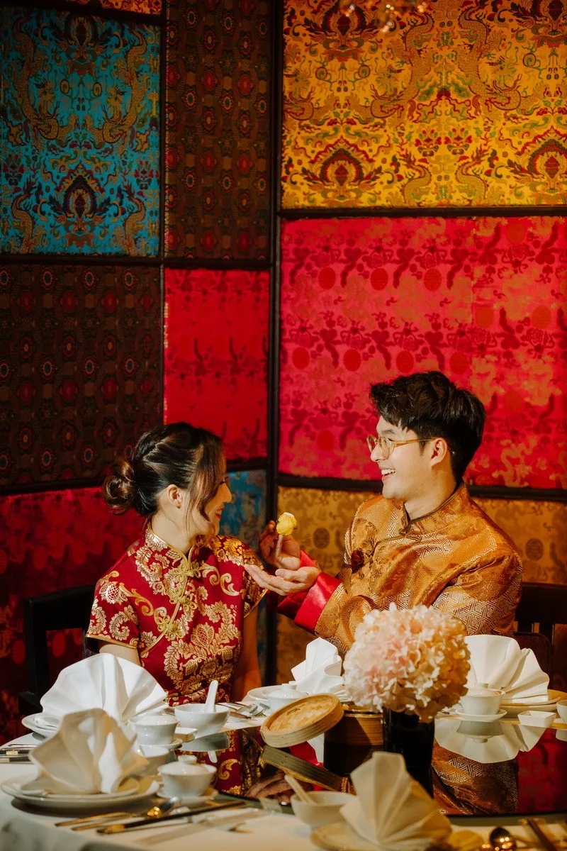 Two people sharing a restaurant meal beneath decorative wall panels