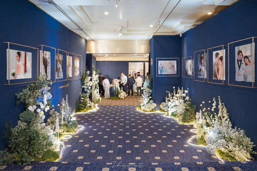 A wedding arrival corridor decorated with flowers and framed photographs