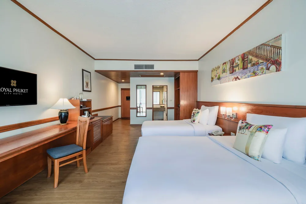 A hotel bedroom with a large bed, desk and an open doorway