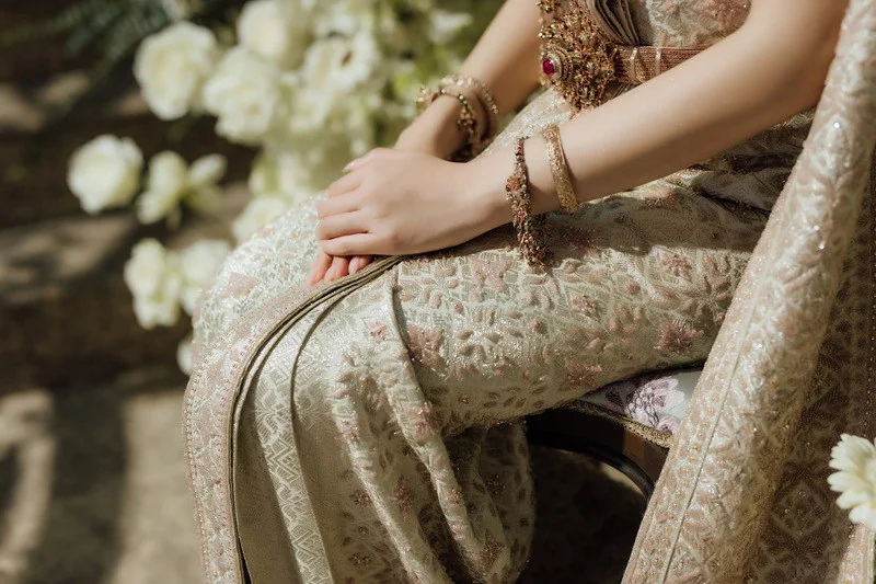 Close detail of joined hands and traditional clothing in supplied Thai wedding photography