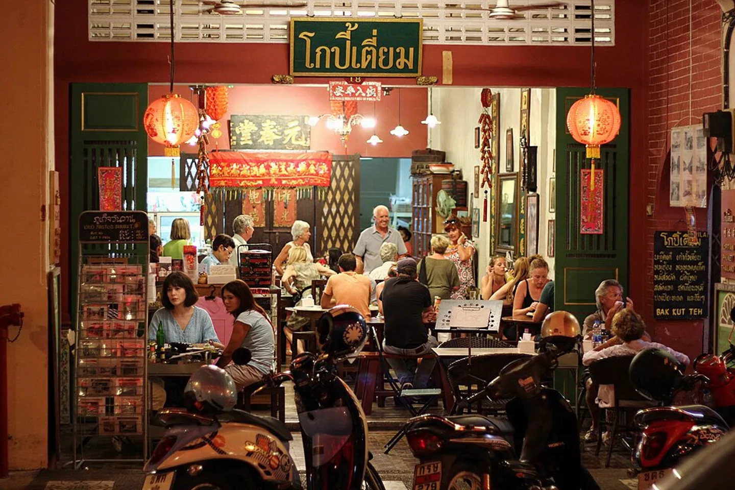 Kopitiam by Wilai storefront and outdoor tables in Phuket Old Town at night